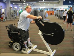 A wheelchair user exercising on gym equipment